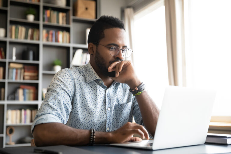 Man looking at a laptop considering his options