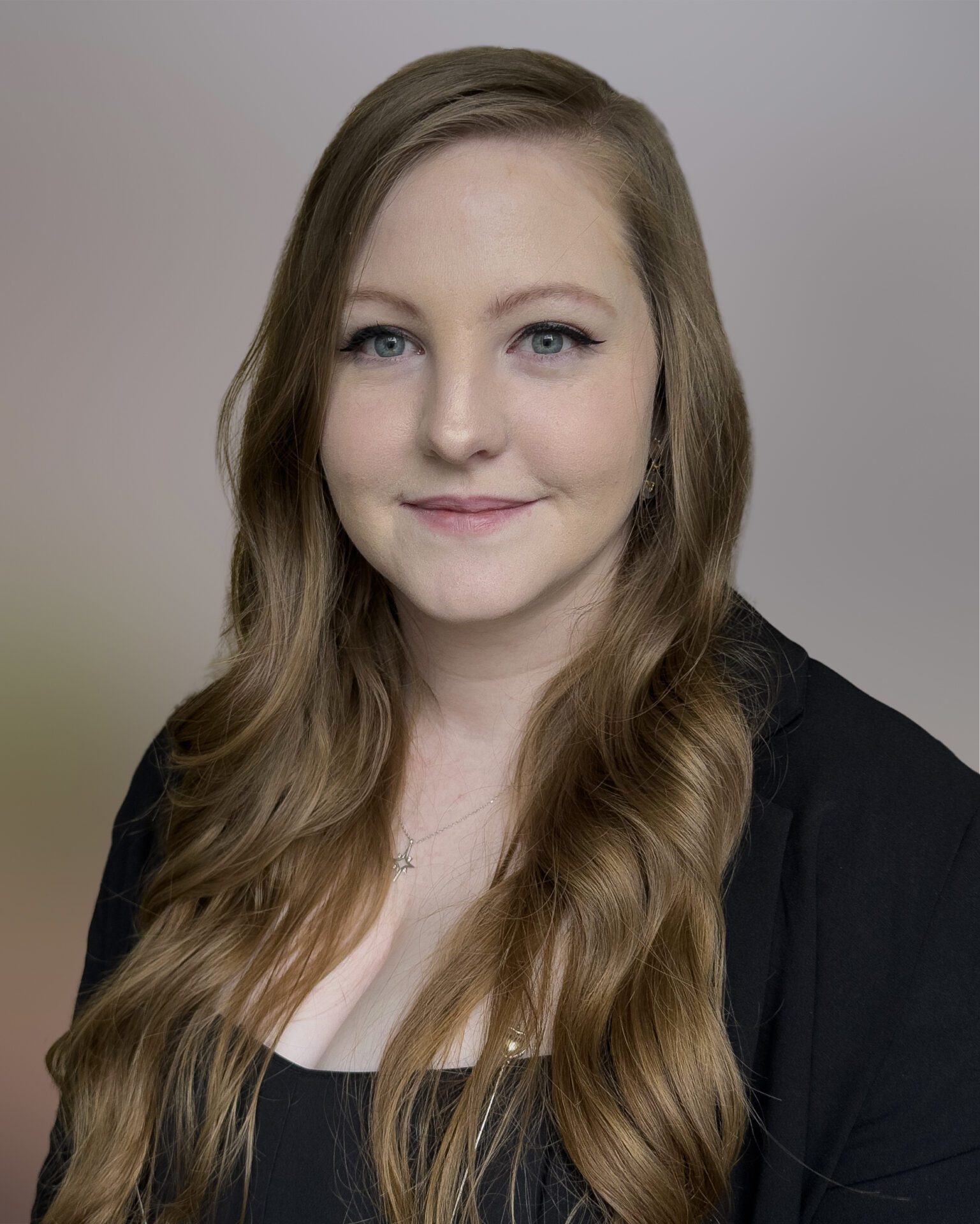 Headshot of Beth Courtney-Walker, wearing a black jacket on a grey background