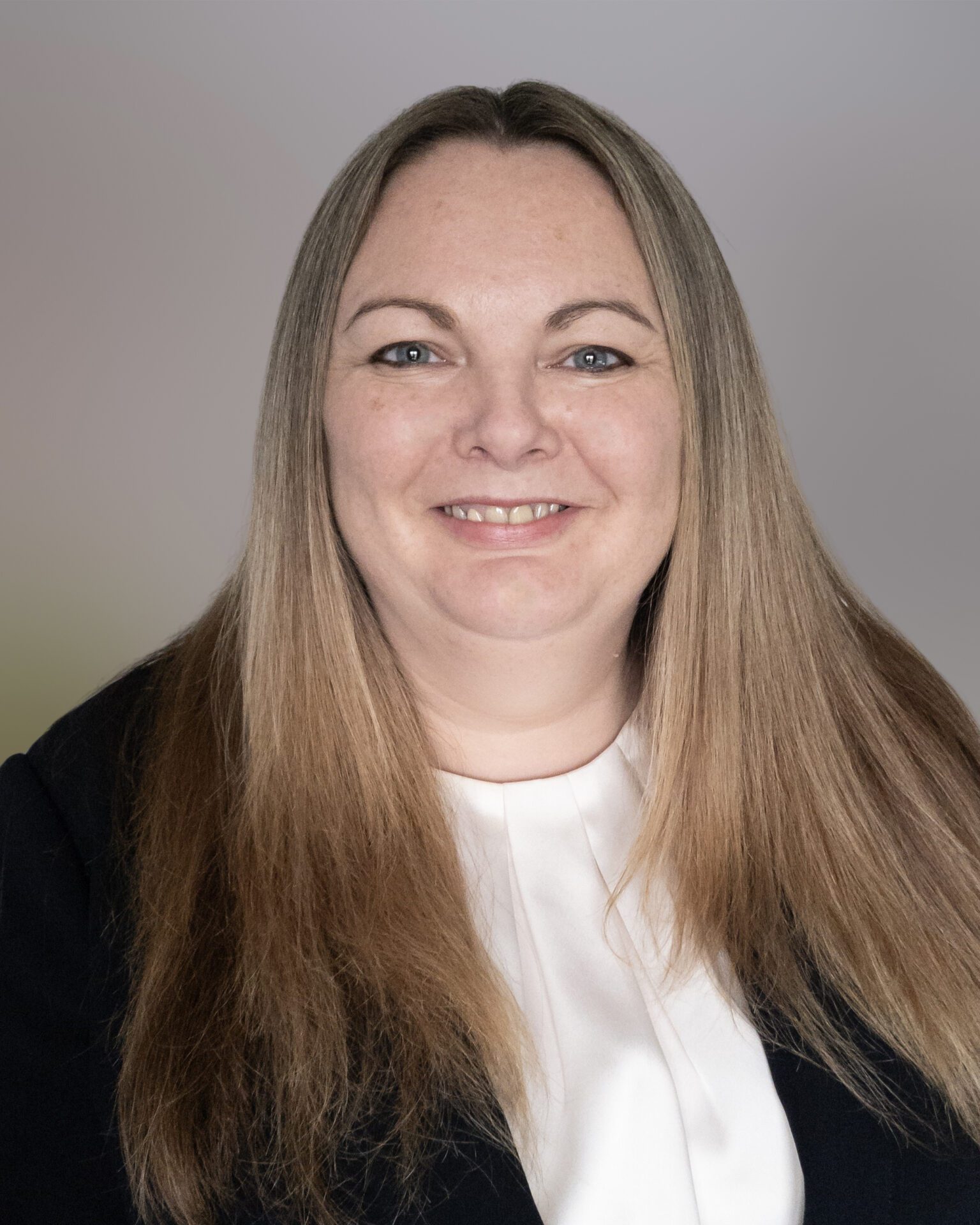 Headshot of Jennifer Hollyer, wearing a white top and black blazer with her blonde hair down