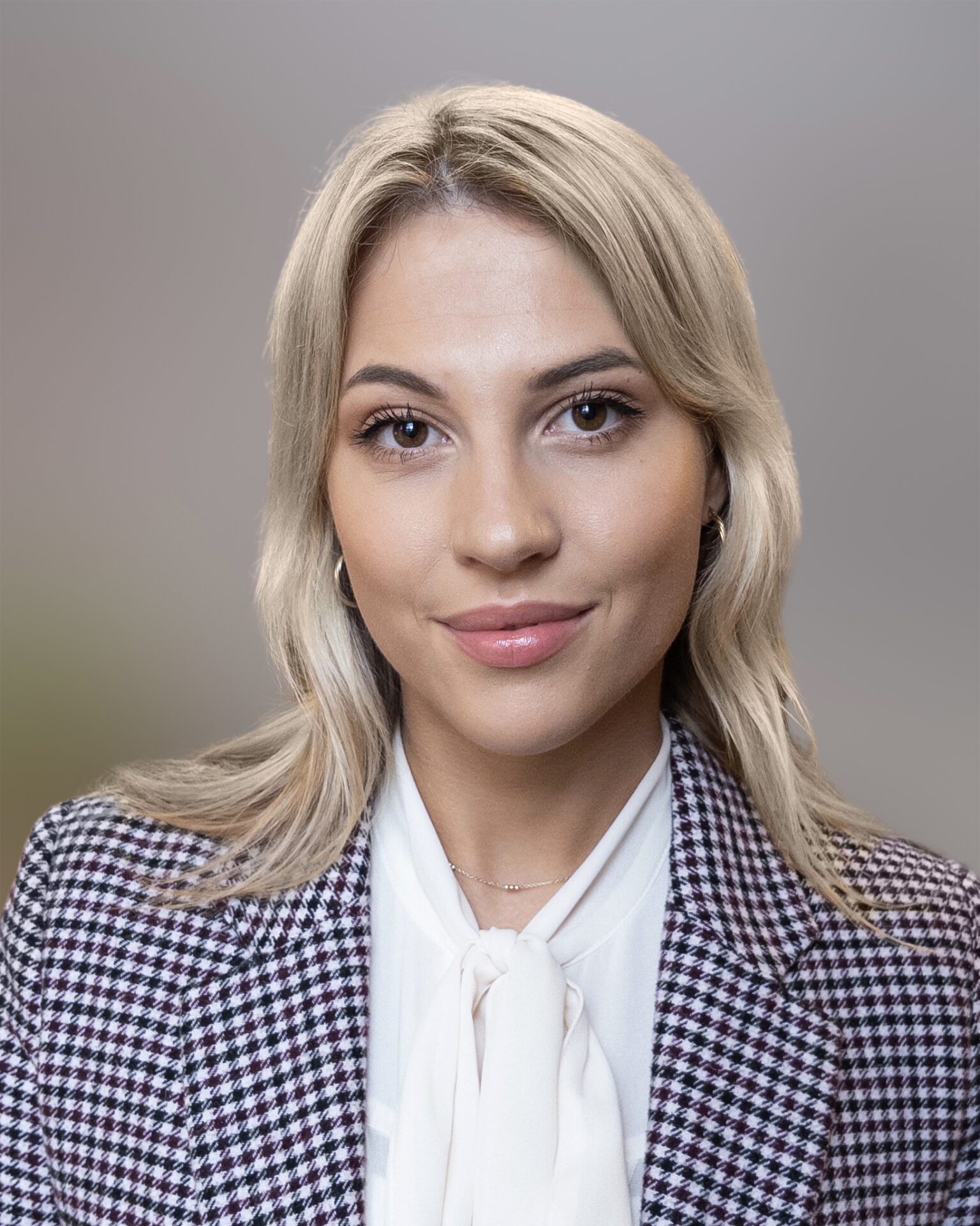 Headshot of Isabella Gill, wearing a white blouse and blazer